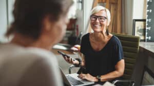 woman talks with colleague at work representing servant leadership and how to balance self and others