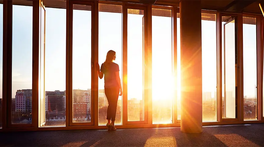 image of business woman looking out window rethinking leadership